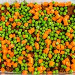 Sprinkle peas and carrots on top of beef mixture.
