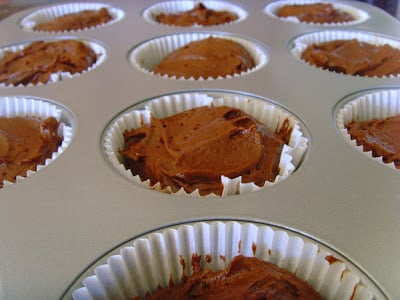 filling the paper cupcake liners with batter while making Chocolate Peanut Butter Cupcakes