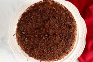 Cover the cake in whipped cream and then with chocolate shavings.