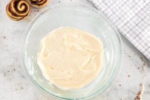 The cream cheese icing all mixed together in a mixing bowl.