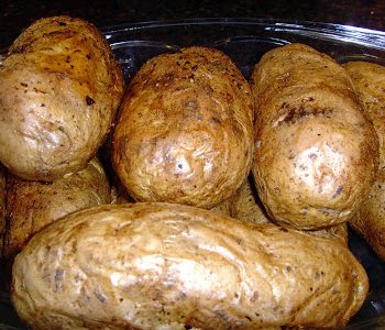 The finished oven baked potatoes on a serving bowl.