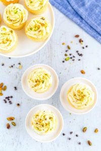 Frost the cupcakes and garnish with pistachios.