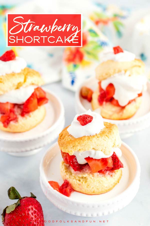 3 Strawberry shortcakes on white pedestals.