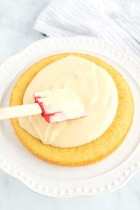 Place a cake round on a cake stand and spread the pastry cream on top.