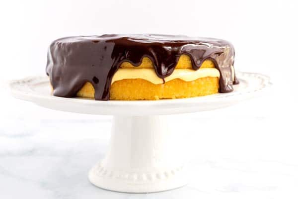 Finished Boston Cream Pie Recipe on a cake pedestal.