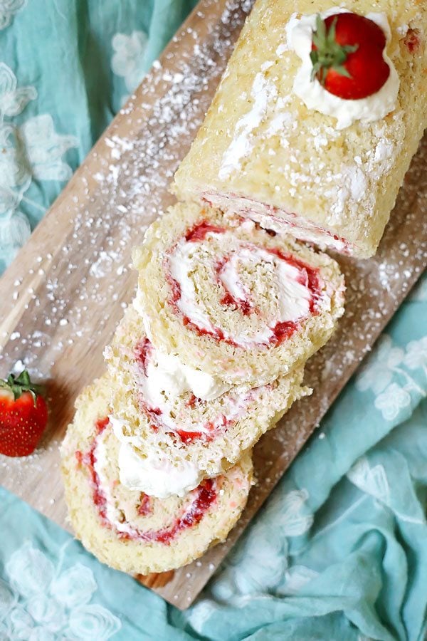 Slices of Strawberry Shortcake Roll Cake on a cutting board