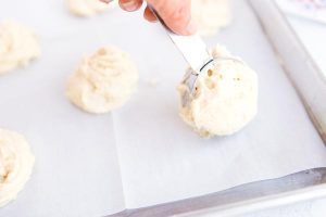 Use a 1/4 cup scoop to scoop the batter onto the prepared baking sheet.