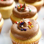 Multiple yellow cupcakes with milk chocolate buttercream