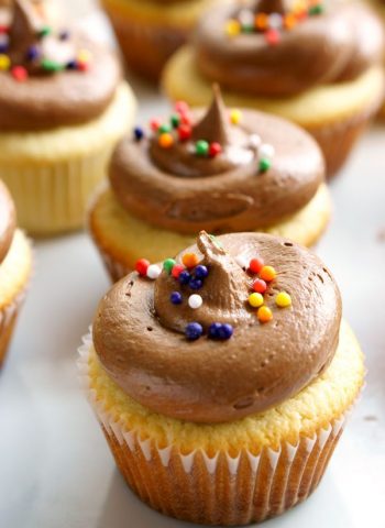 Multiple yellow cupcakes with milk chocolate buttercream