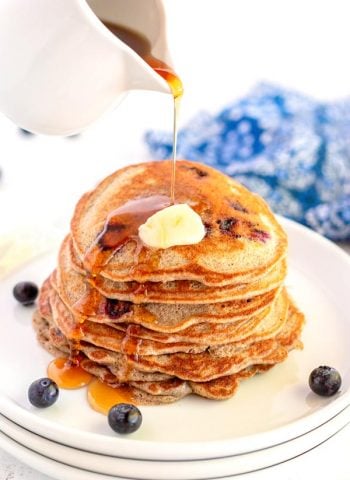 Buttermilk Buckwheat pancakes with syrup being poured over them.