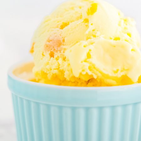 A scoop of peach ice cream in a blue dish.