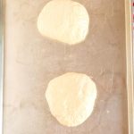 Place the dough balls on a greased baking sheet, and cover with greased plastic wrap while th dough sits at room temperature for an hour.