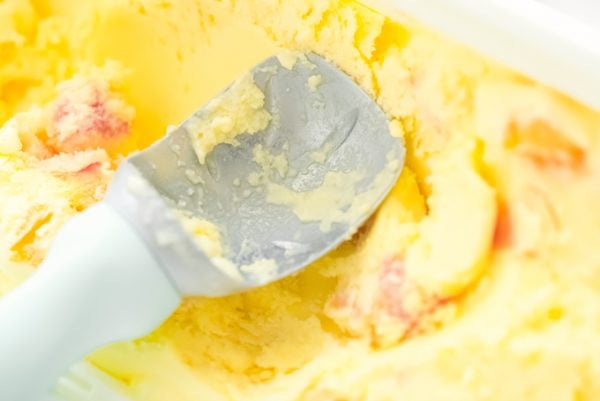 Peach Ice Cream with an ice cream scoop.