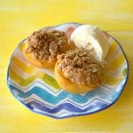 Baked peaches with oat crumble topping on a plate