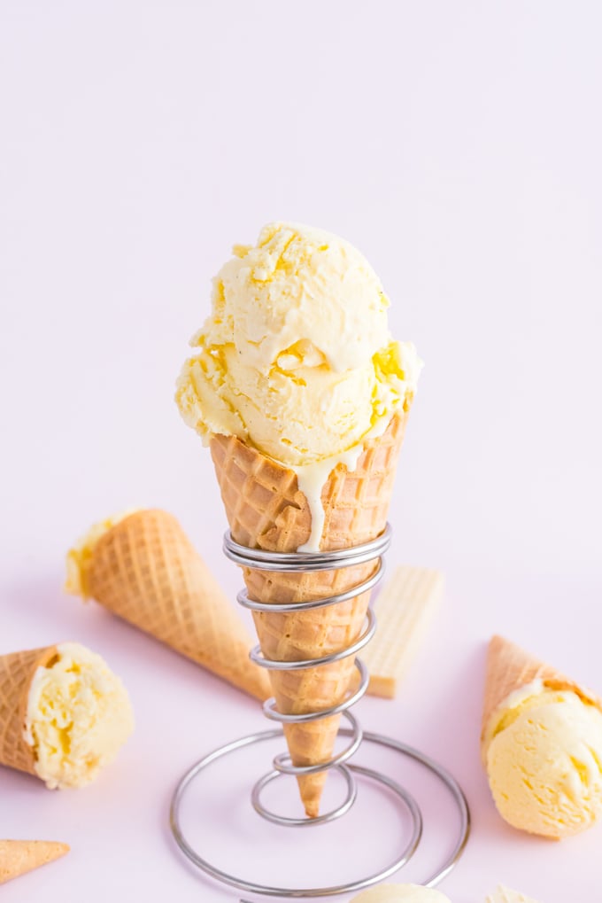 Vanilla Custard in a cone with other scoops of ifrozen custard surrounding it.