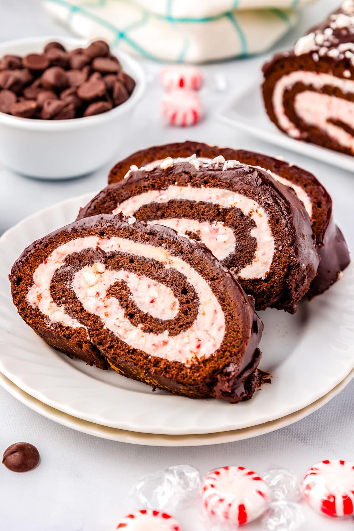 Three slices of Christmas Cake Roll on a white plate.