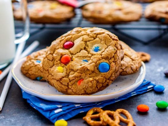 Cookies on a plate with pretzels and M&Ms around it.