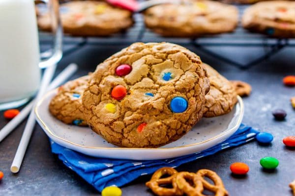 Cookies on a plate with pretzels and M&Ms around it.
