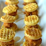 Two rows of chicken and waffles on a serving platter