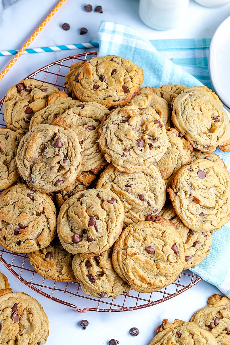 Best Peanut Butter Chocolate Chip Cookies EVER! They're piled high on a wire rack.