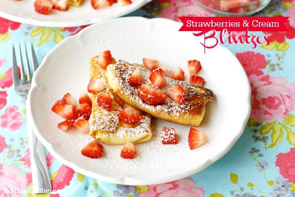 Strawberries and Cream Cheese Blintzes on a plate with text overlay for Pinterest