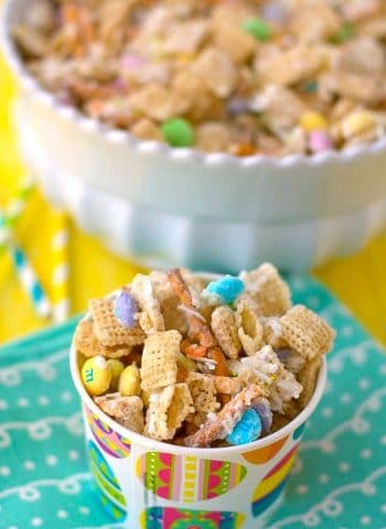 Bunny Bait Snack Mix in a decorative paper cup on top of a pretty blue napkin.