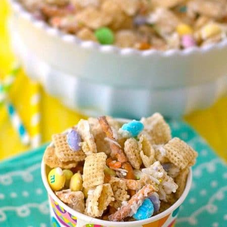 Bunny Bait Snack Mix in a decorative paper cup on top of a pretty blue napkin.