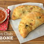 Two calzones on a table with text overlay for Pinterest
