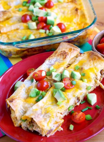 Breakfast Enchiladas on a plate with a baking dish in the background