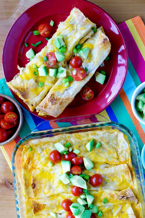 Overhead shot of breakfast enchiladas on a plate and in a casserole dish.