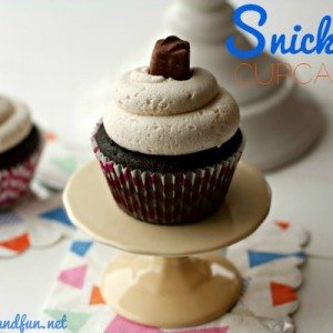 One Snickers Cupcake with Caramel Butterceam frosting with text overlay for Pinterest.