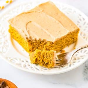 A close up of a piece of Pumpkin Sheet Cake on a white plate.