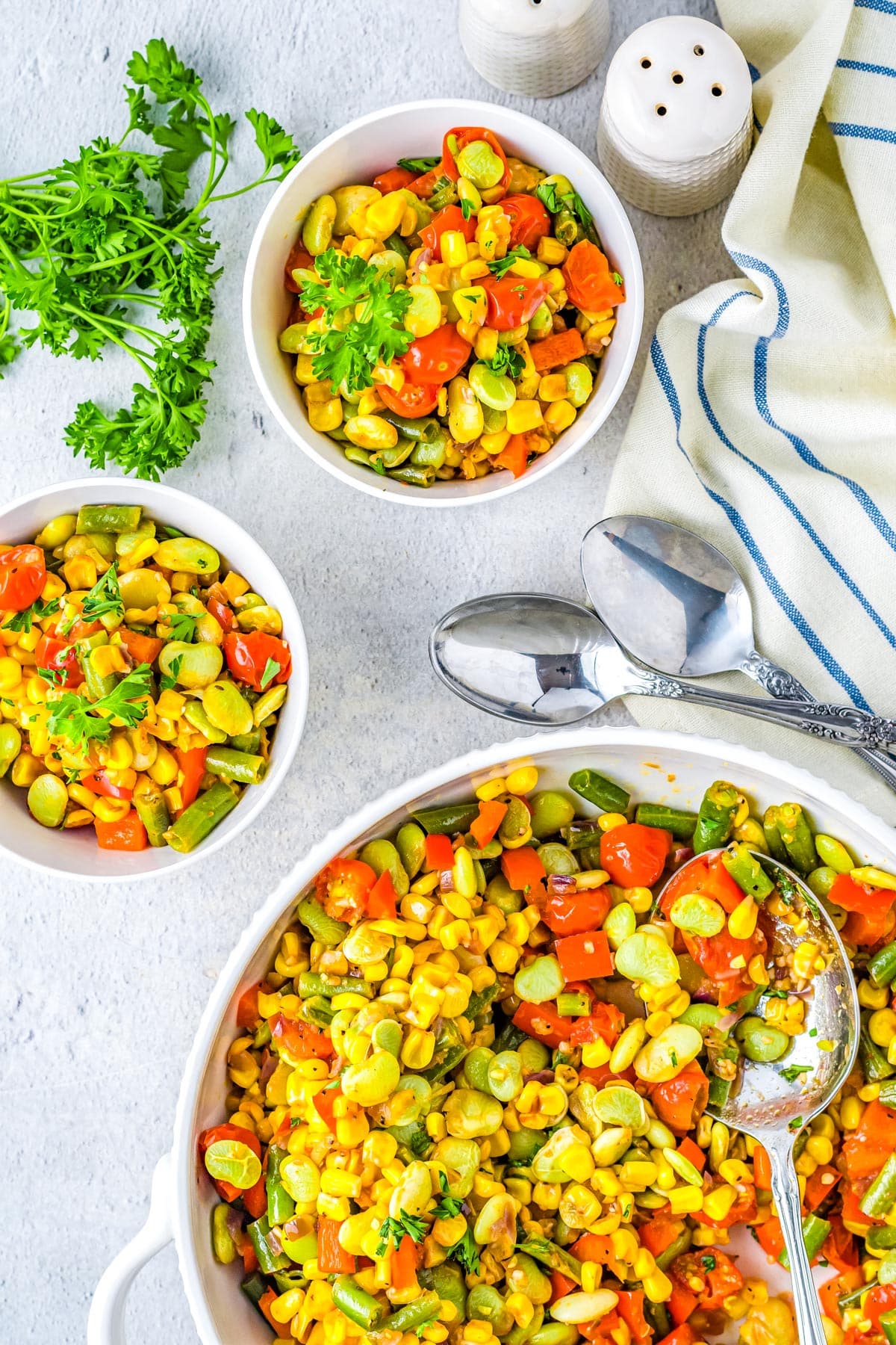 An overhead picture of the finished Corn Succotash on a serving bowl and in smaller dishes.