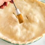 Brush the top pie crust with egg white.