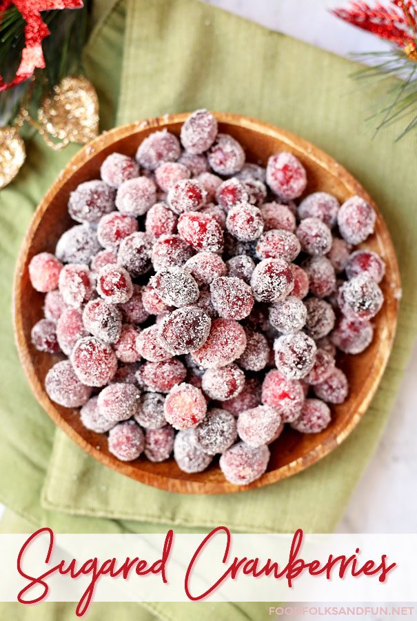 An overhead picture of frosted cranberries in a wooden bowl.