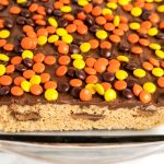 Spread the melted chocolate on top and top with Reese's pieces. Let set for 1 hour.