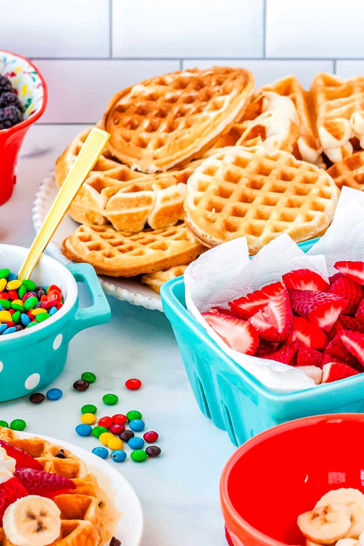 All of the diferent elements of teh waffle toppings bar on a countertop.