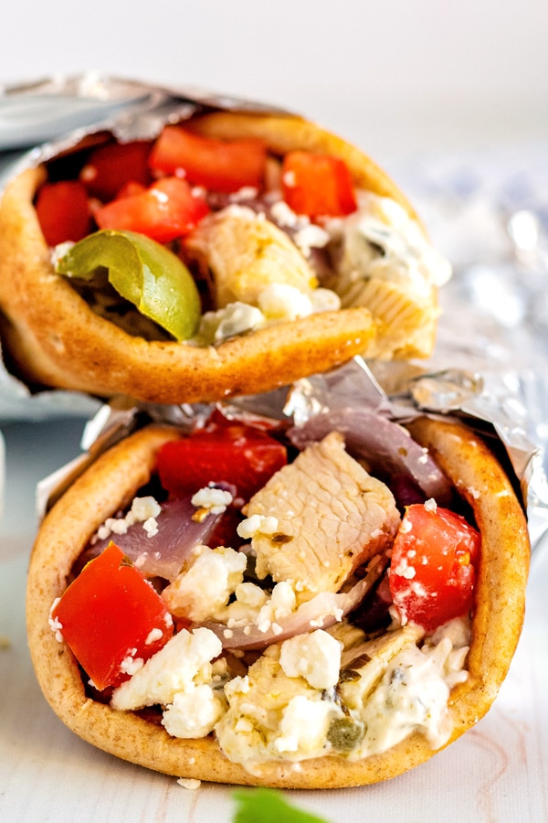 Two Chicken souvlaki pitas stacked on top of each other.