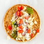 Place the chicken souvlaki mixture and toppings on the pita.