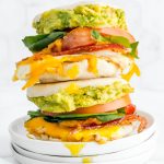 Breakfast sandwiches stacked on top of each other with runny yolks.