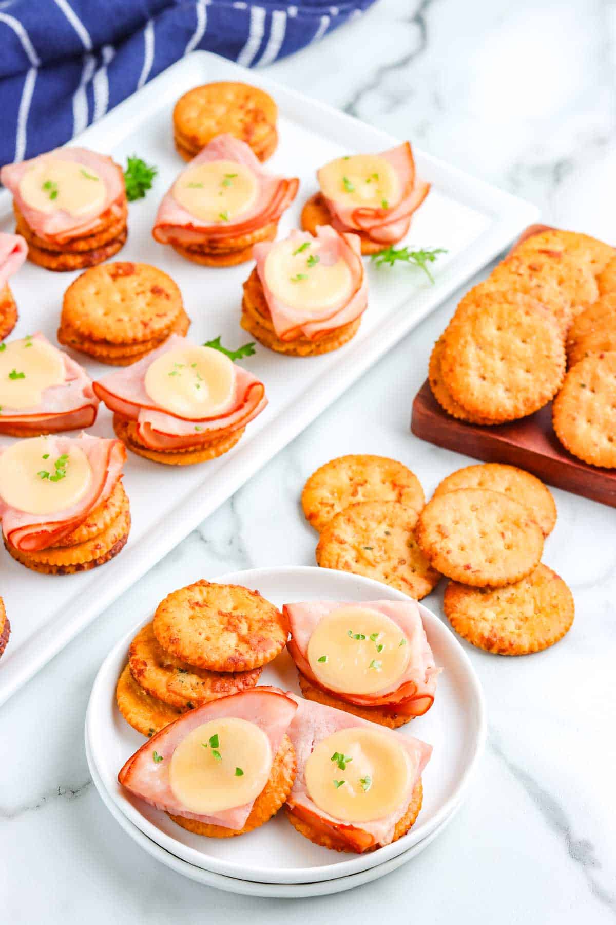 Ranch Crackers on a serving platter and some topped with ham and Swiss cheese.