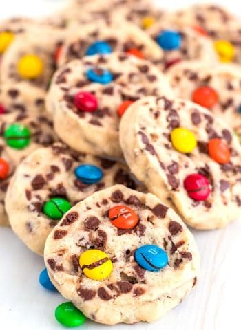 A pile of shortbread cookies with M&Ms on them.