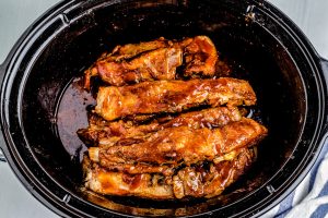After the ribs have cooked, slather them with barbecue sauce.