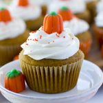 A close up of a pumpkin cupcake with marshmallow buttercream