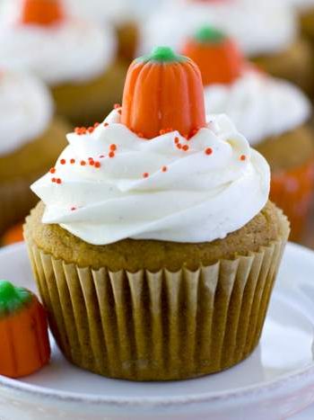 A close up of a pumpkin cupcake with marshmallow buttercream