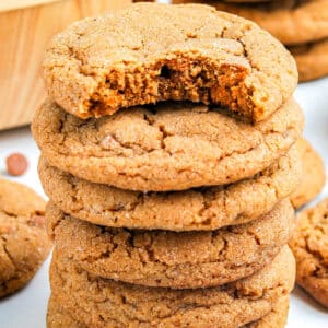 Pumpkin Snickerdoodle cookies stacked on each other with a bite taken out of the top one.