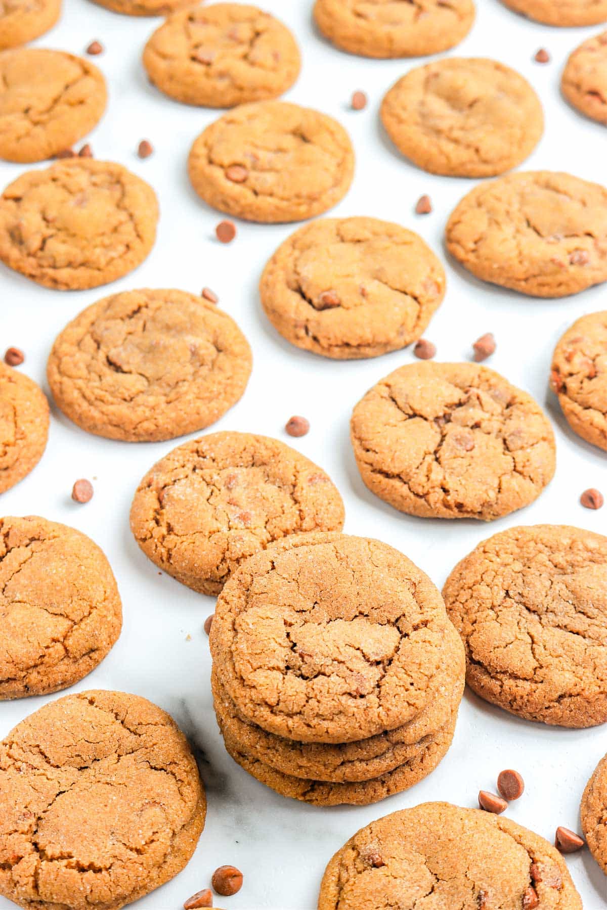 Cookies on a white table top with cinamon chips surrounding them.