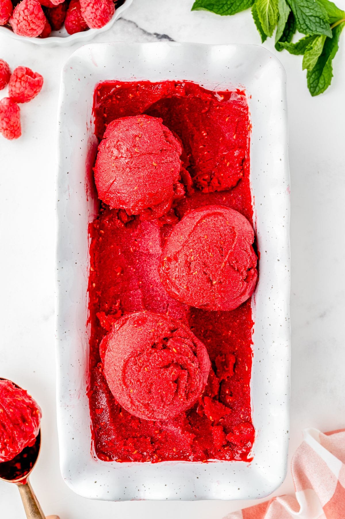 An overhead picture of the finished Raspberry Sorbet recipe and three scoops on top.