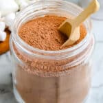 The finished Homemade Hot Chocolate Mix in a Mason jar with a small wooden scoop.