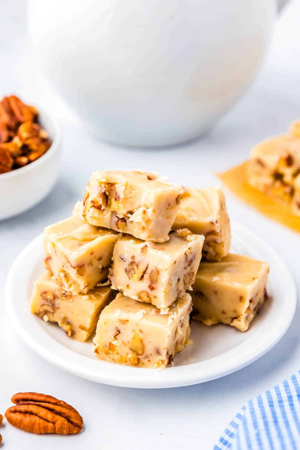 A pile of the finished Butter Pecan Fudge on a white plate. 